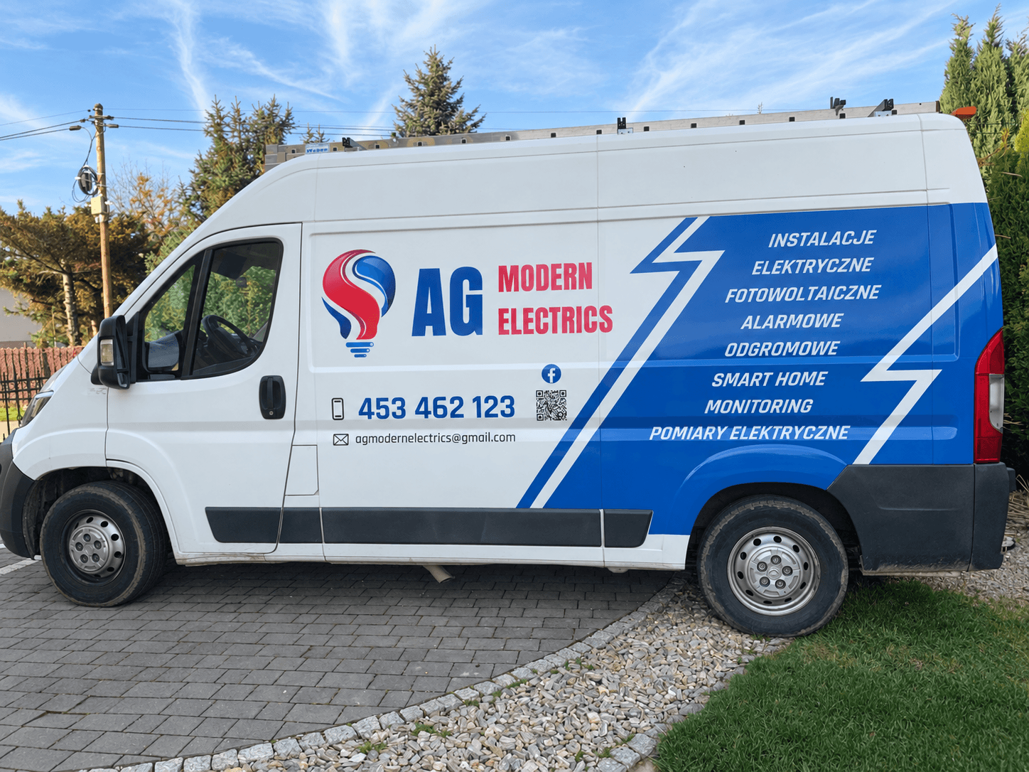 Samochód firmowy AG Modern Electrics z oznakowaniem usług i kontaktem